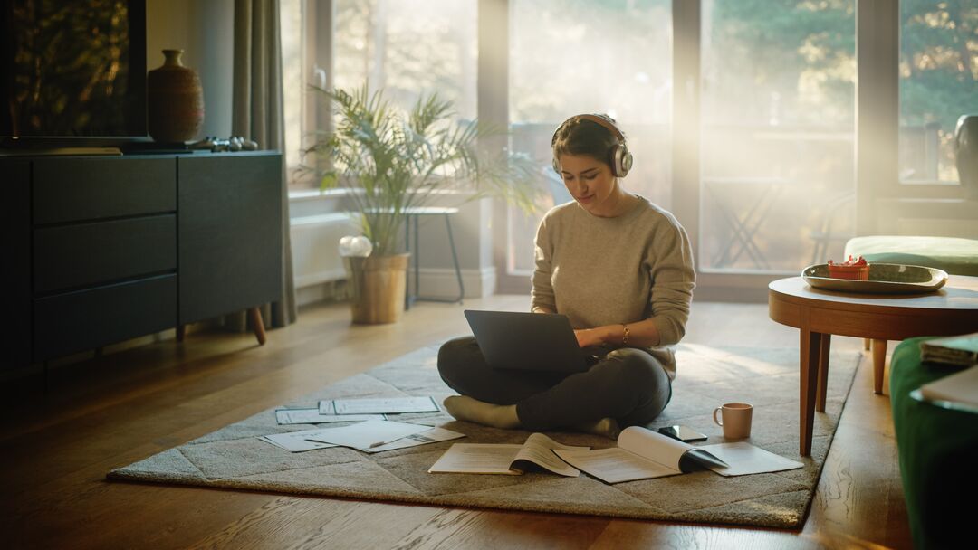 Beautiful Smiling Girl Sitting on the Floor Does Research on Papers,